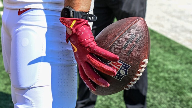 Commanders player holding an NFL football